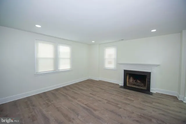 an empty room with windows and fireplace