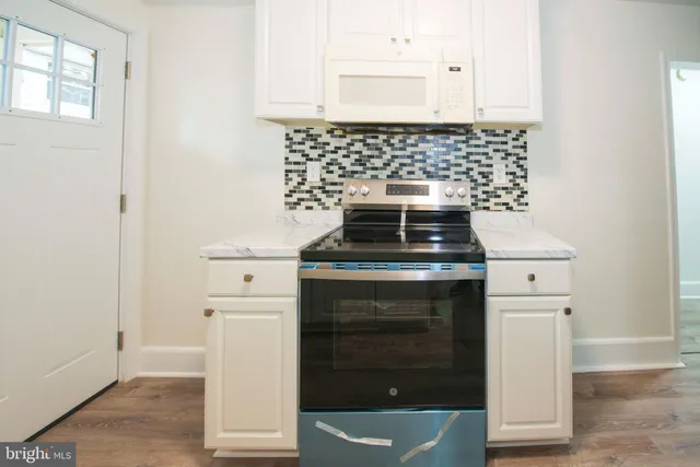 a kitchen with a stove and white cabinets