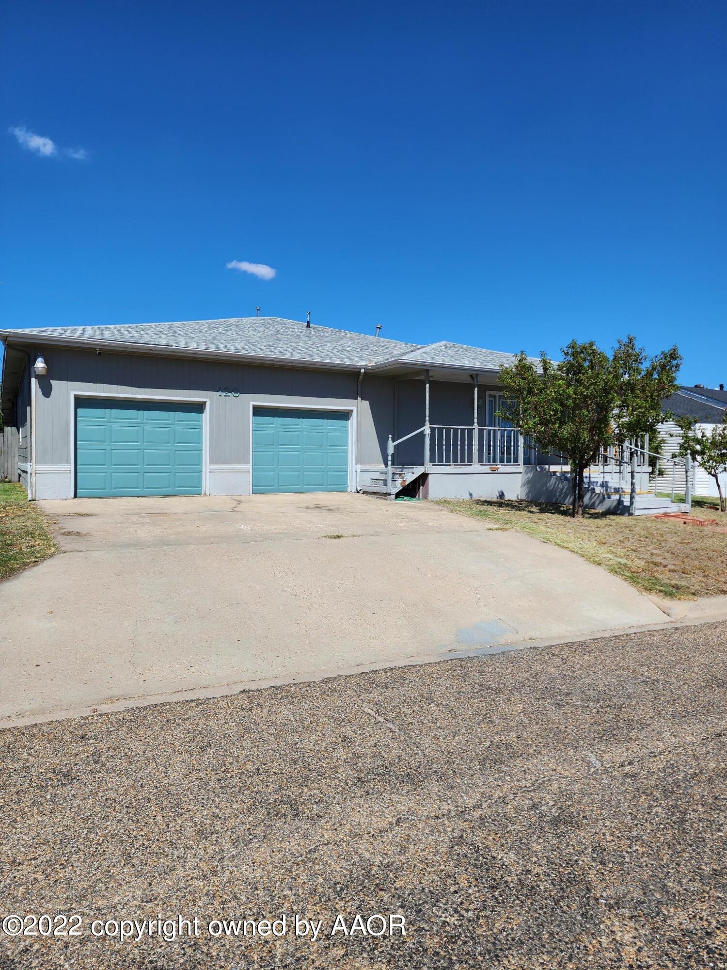 120 Pinon Street Borger, TX 79007 - Photo 2 of 19 a backyard of a house with table and chairs under an umbrella