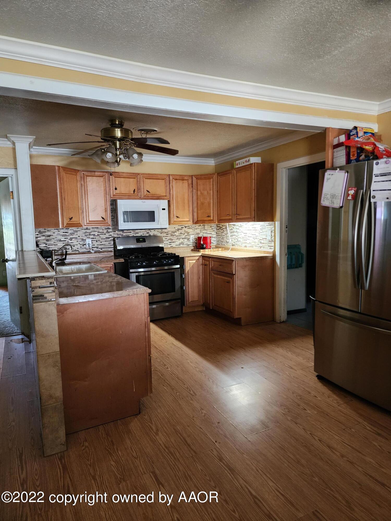 120 Pinon Street Borger, TX 79007 - Photo 5 of 19 a kitchen with stainless steel appliances granite countertop a stove a sink and a refrigerator