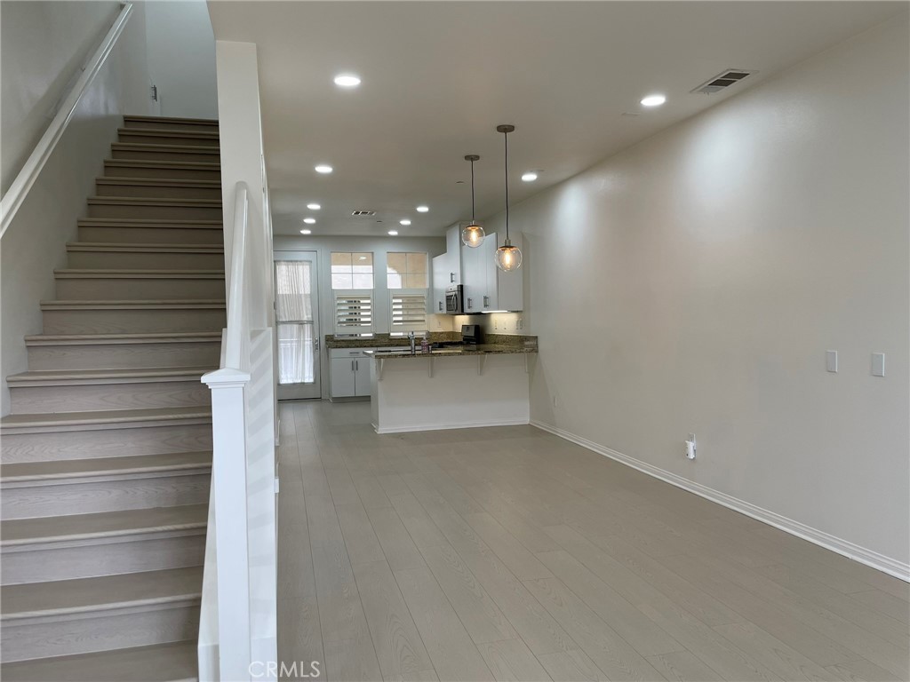 810 The Promenade, Unit C Azusa, CA 91702 - Photo 13 of 38 a view of a kitchen with kitchen island wooden floor and stainless steel appliances