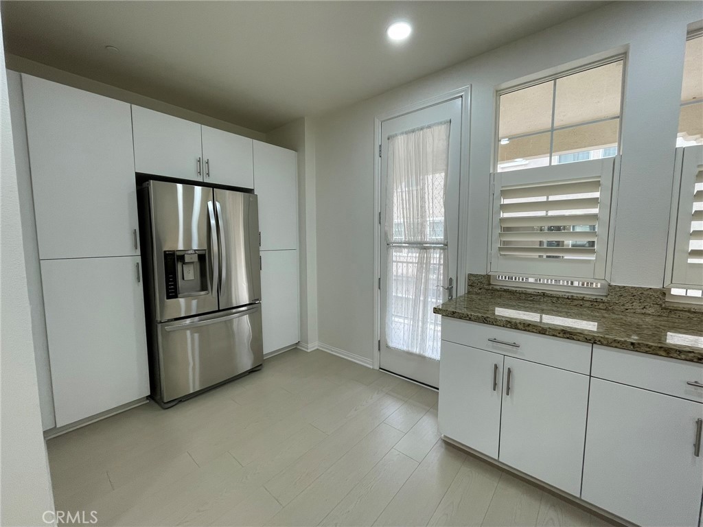 810 The Promenade, Unit C Azusa, CA 91702 - Photo 15 of 38 a kitchen with stainless steel appliances granite countertop a refrigerator a sink a stove and white cabinets