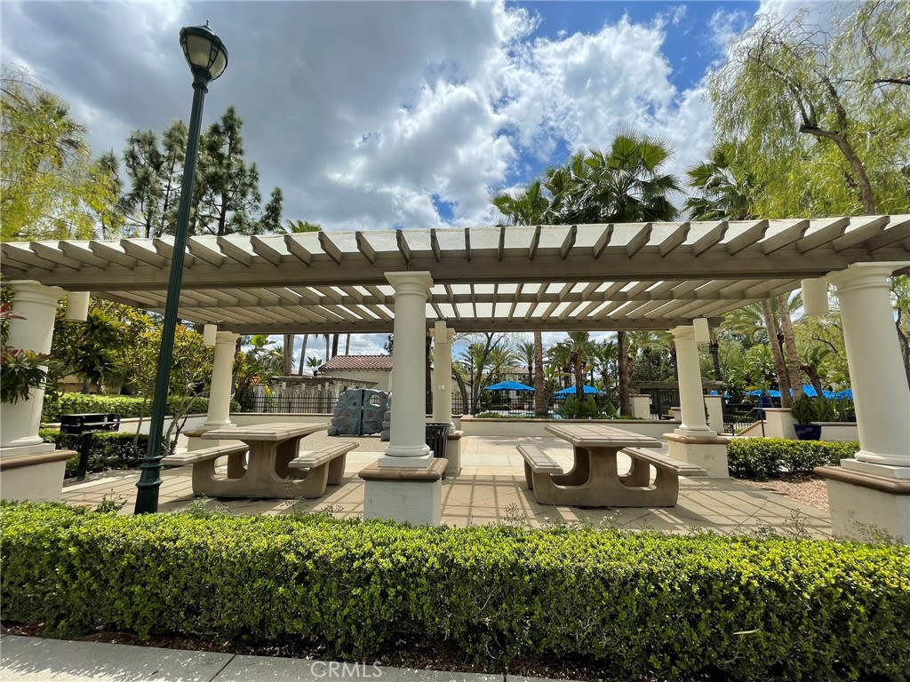 810 The Promenade, Unit C Azusa, CA 91702 - Photo 33 of 38 a view of a patio with table and chairs potted plants and palm trees