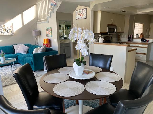 79798 Olympia Fields La Quinta, CA 92253 - Photo 3 of 25 a dining room with furniture a kitchen wooden floor and a chandelier