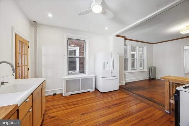 a view of kitchen with sink and refrigerator