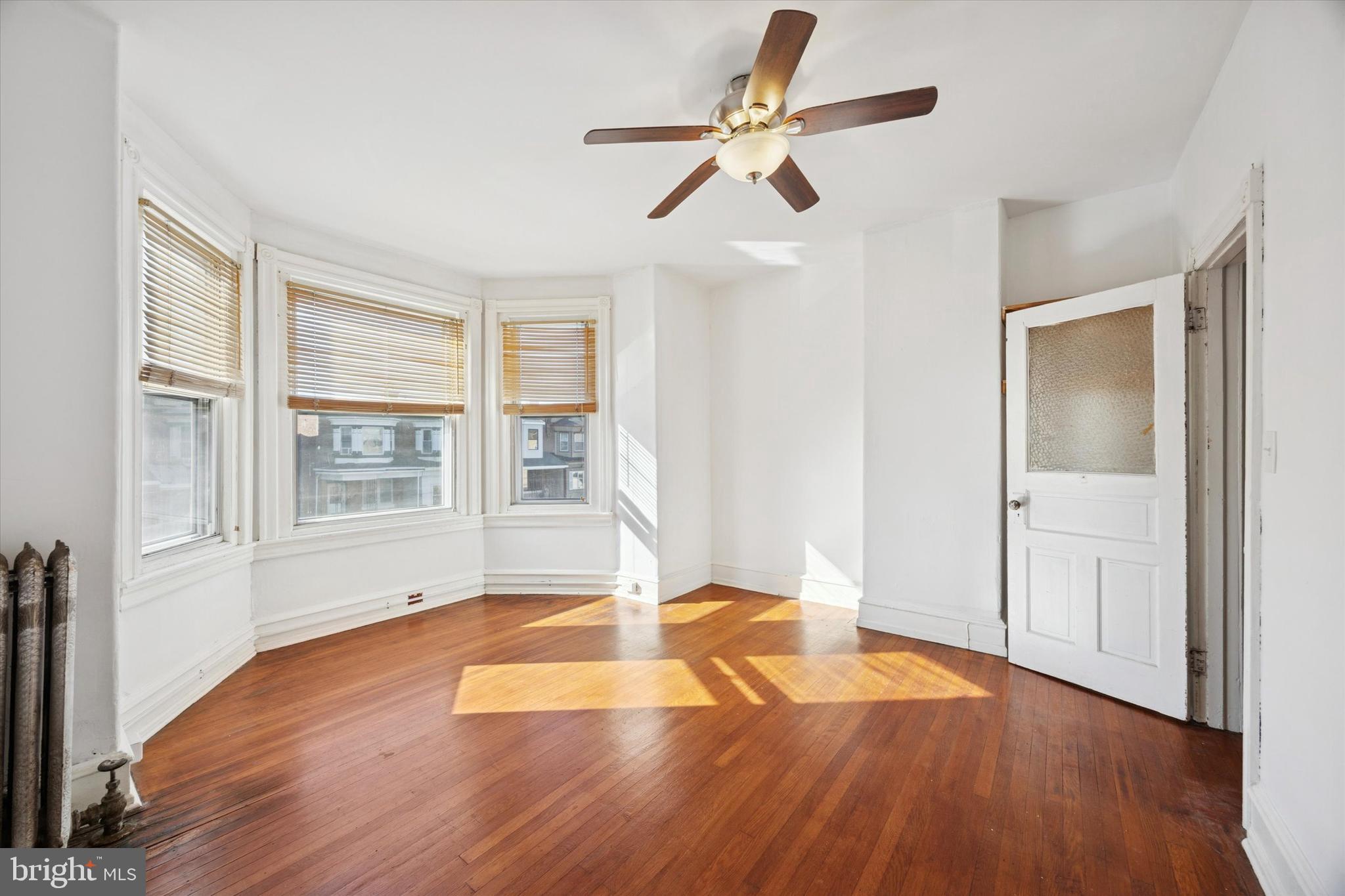 1227 South 53rd Street Philadelphia, PA 19143 - Photo 19 of 31 an empty room with wooden floor fan and windows