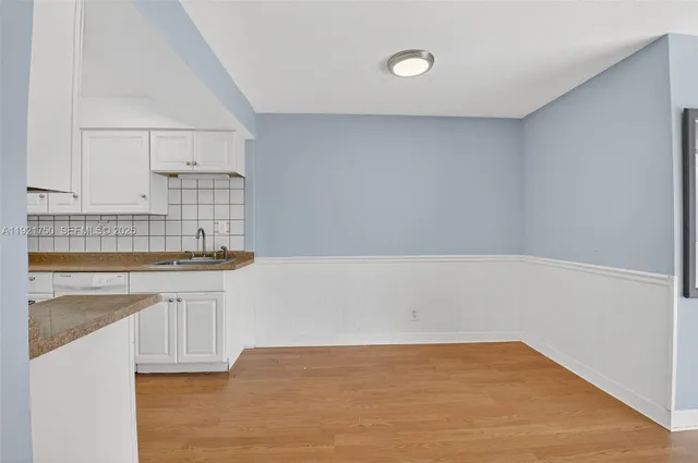 a kitchen with granite countertop white cabinets and sink