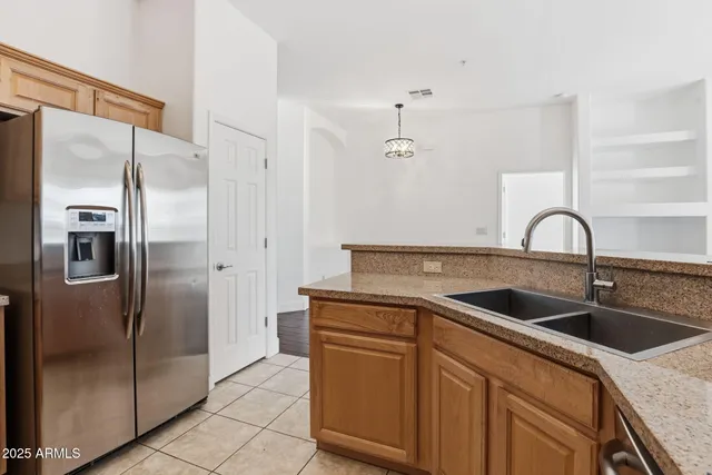a kitchen with stainless steel appliances granite countertop a refrigerator and a sink