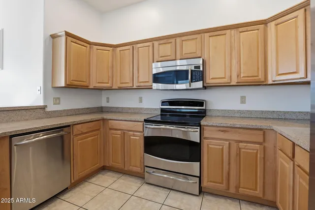 a kitchen with stainless steel appliances granite countertop a stove microwave and cabinets