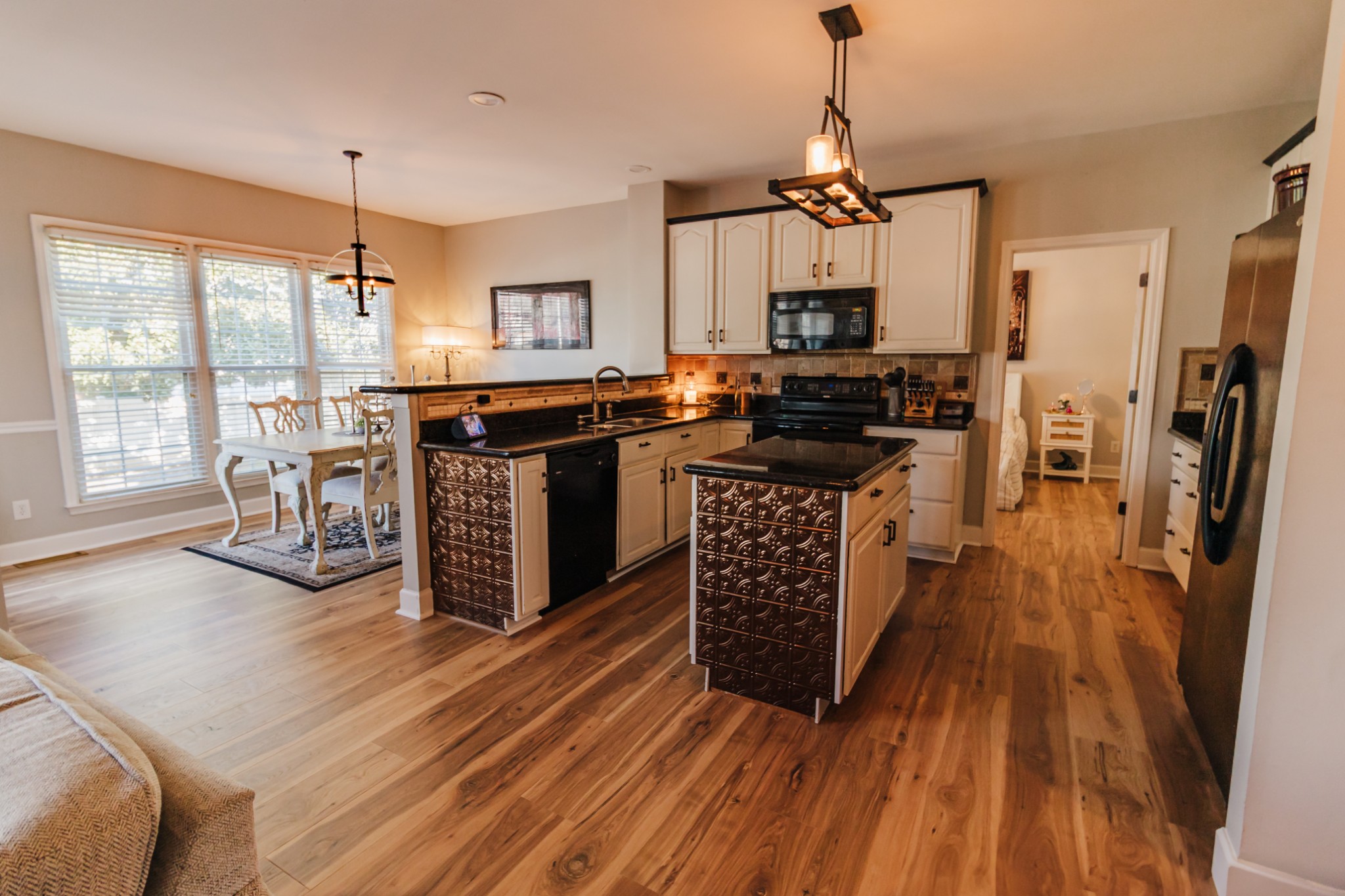 203 Savannah Ridge Murfreesboro, TN 37127 - Photo 8 of 60 a kitchen with stainless steel appliances granite countertop a stove top oven a refrigerator a dining table and chairs with wooden floor