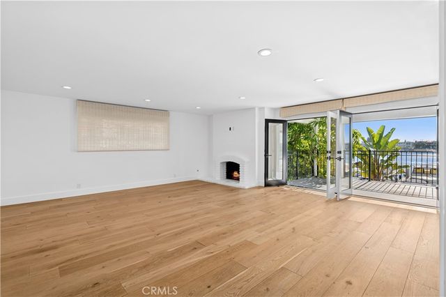 an empty room with wooden floor and outdoor view
