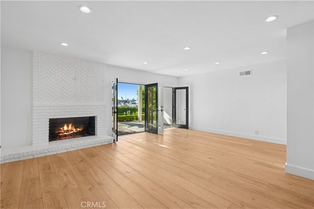a view of an empty room with a fireplace and a window