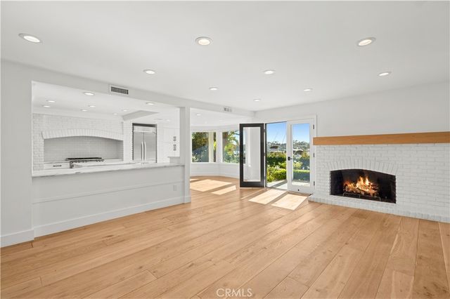 a view of empty room with wooden floor and a fireplace