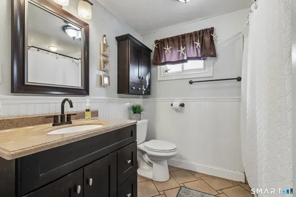 a bathroom with a toilet sink and mirror