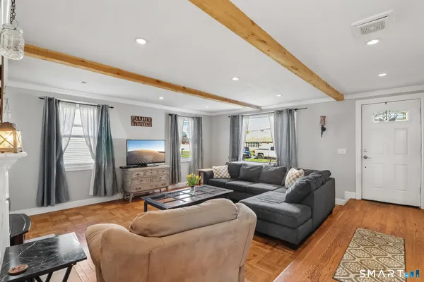 a living room with furniture and a wooden floor