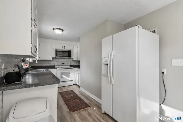 a kitchen with white cabinets and stainless steel appliances