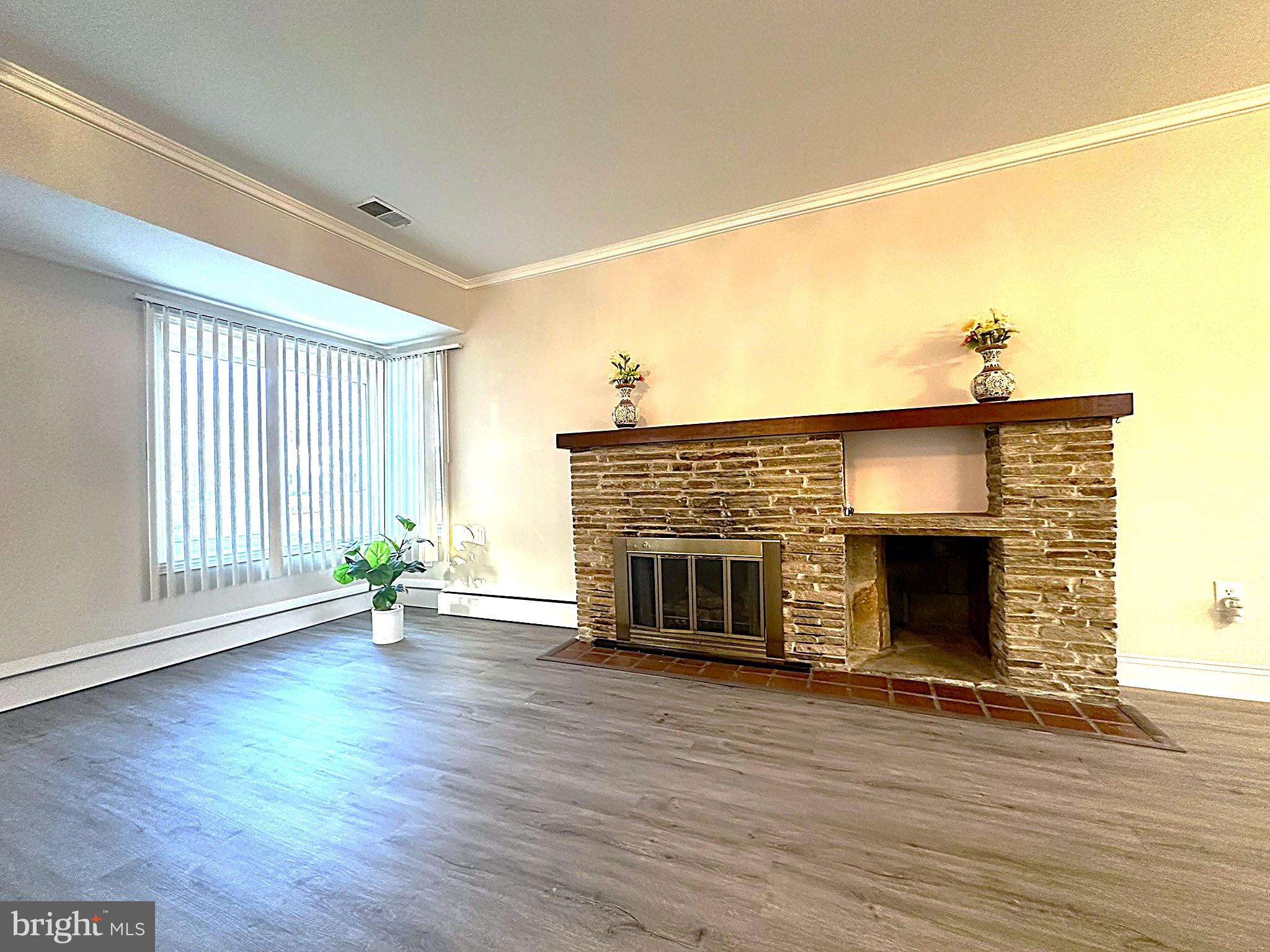 4121 Villa Nova Road Baltimore, MD 21207 - Photo 19 of 57 an empty room with wooden floor fireplace and windows