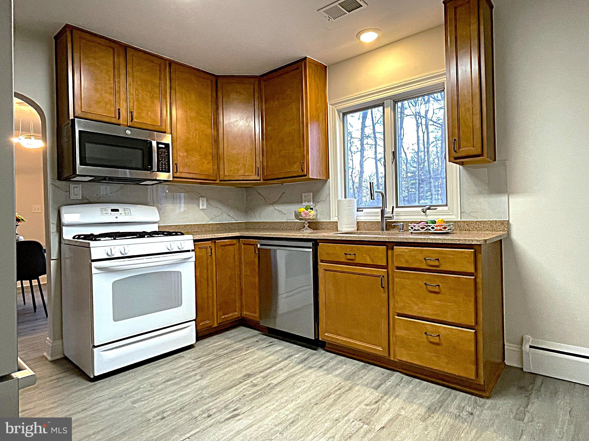 4121 Villa Nova Road Baltimore, MD 21207 - Photo 28 of 57 a kitchen with stainless steel appliances granite countertop wooden cabinets a stove top oven a sink and dishwasher