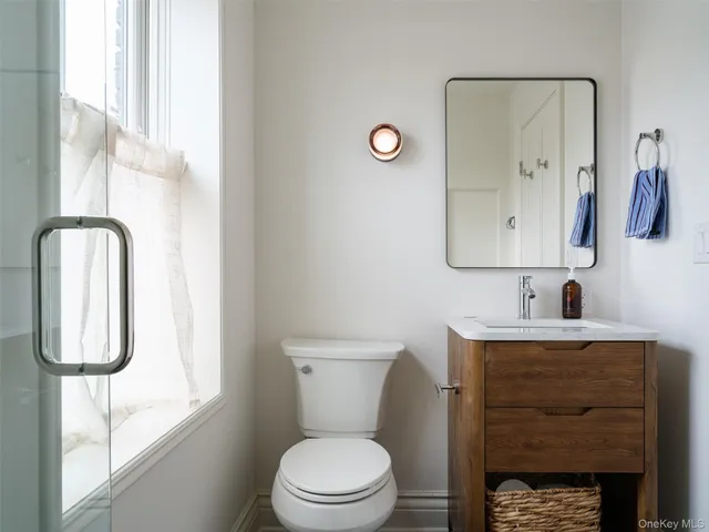 a bathroom with a toilet sink and mirror