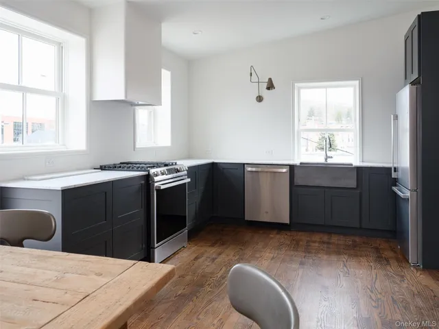 a kitchen with stainless steel appliances kitchen island granite countertop a stove a sink and a refrigerator