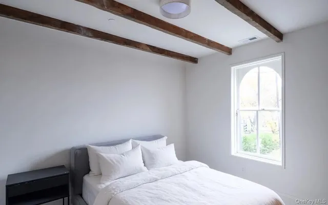 a bedroom with a bed and a window