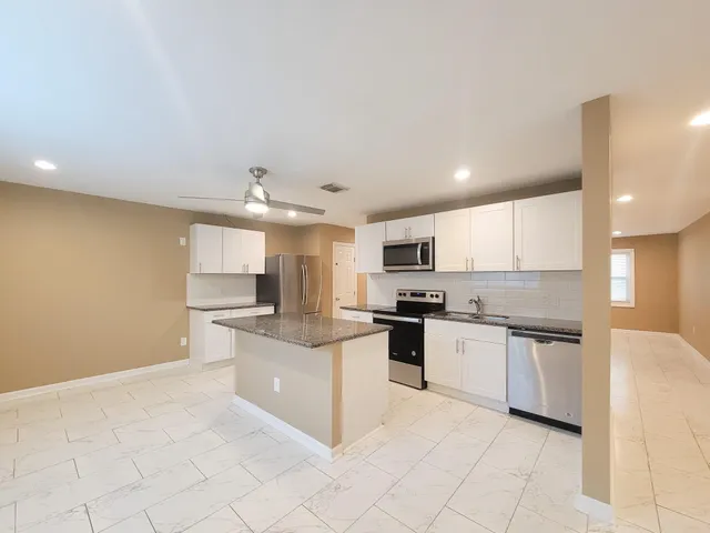 a kitchen with stainless steel appliances a refrigerator sink and stove