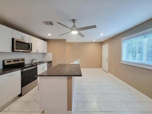 a kitchen with granite countertop a stove and a sink