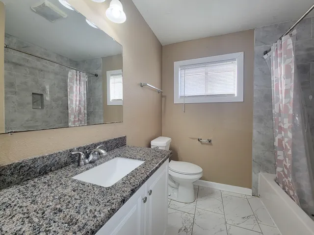 a bathroom with a granite countertop sink and a mirror
