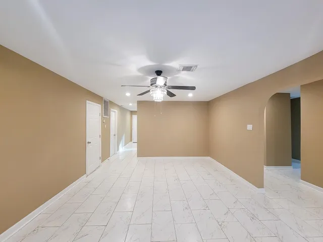 a view of an empty room with closet and a chandelier fan
