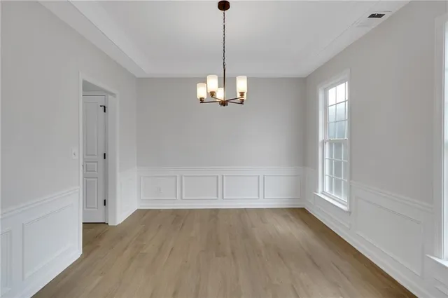 a view of a big room with wooden floor kitchen and windows
