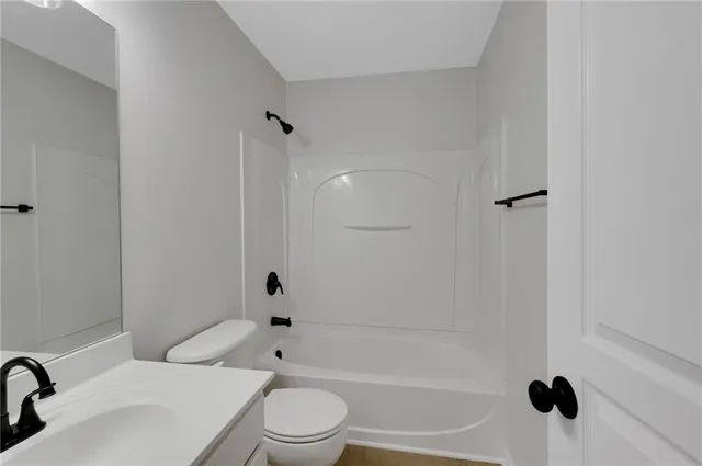 an empty room with ceiling fan and windows