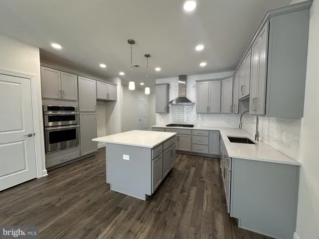 a large kitchen with stainless steel appliances a sink a stove and a refrigerator