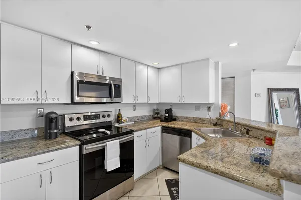 a kitchen with stainless steel appliances granite countertop a sink stove a sink and cabinets