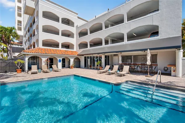 a view of house with swimming pool and sitting area