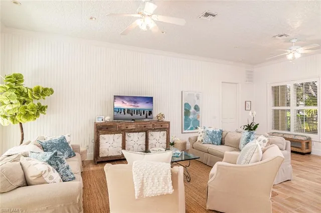 a living room with furniture a chandelier and a potted plant
