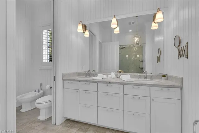 a bathroom with a double vanity sink toilet and a mirror