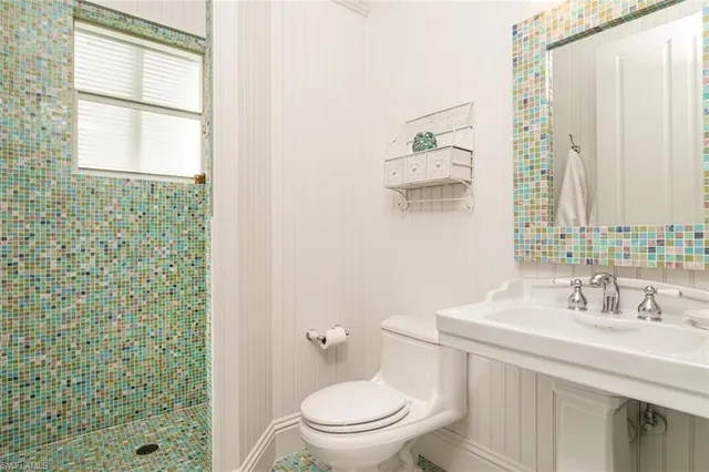 a bathroom with a sink a toilet and a window