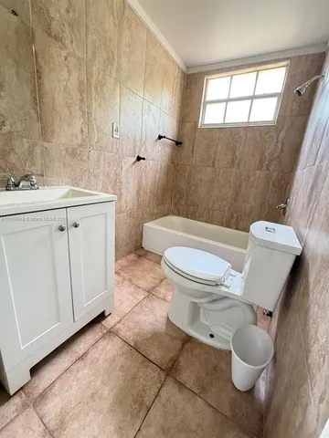 a white toilet sitting next to a bathroom sink and tub