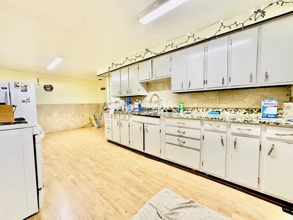a kitchen with granite countertop a sink a stove and cabinets