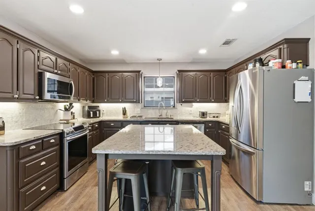 a kitchen with granite countertop stainless steel appliances and wooden cabinets