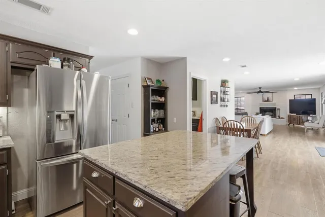 a kitchen with stainless steel appliances granite countertop a sink refrigerator and cabinets