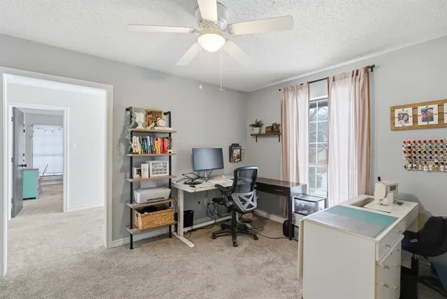 a view of a workspace with furniture and a window