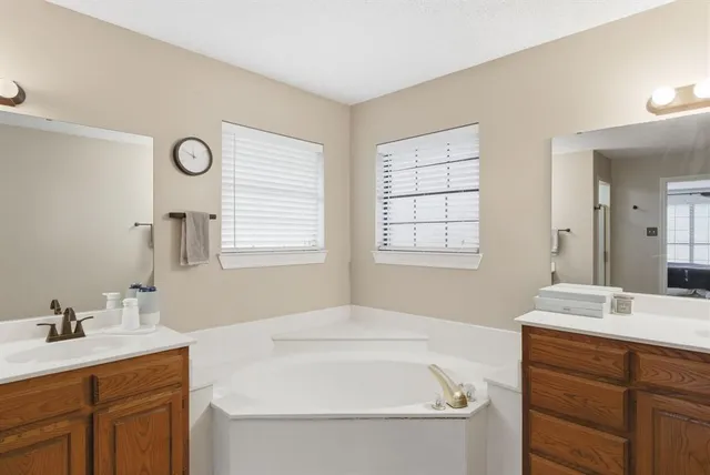 a bathroom with a tub sink and mirror