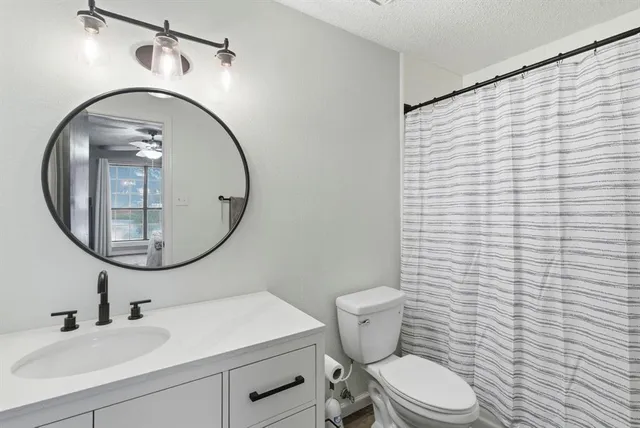 a bathroom with a toilet a sink and mirror