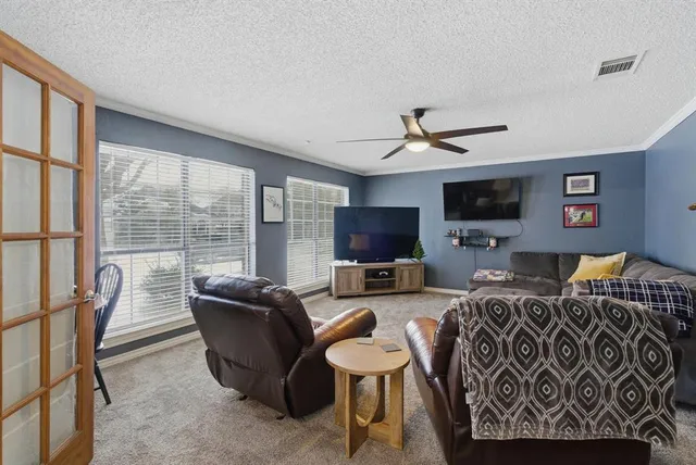 a living room with furniture a flat screen tv and a large window