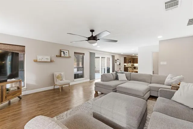 a living room with furniture and a wooden floor