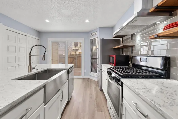 a kitchen with stainless steel appliances granite countertop a sink stove and cabinets
