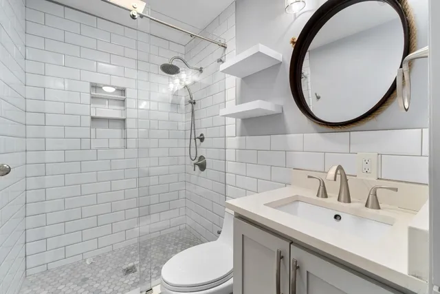 a bathroom with a sink mirror toilet and shower