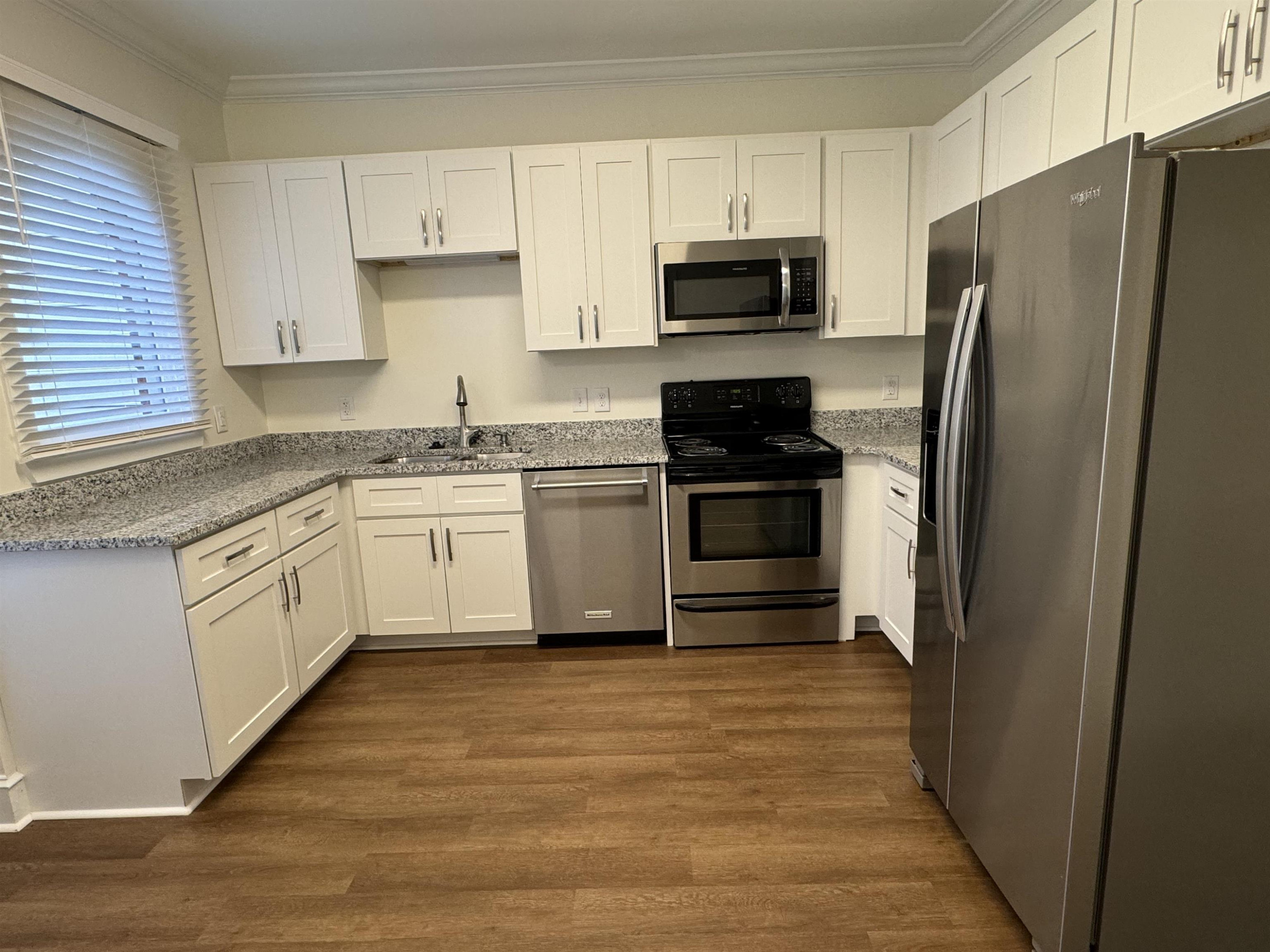 1419 Fowlkes Place Raleigh, NC 27612 - Photo 2 of 9 a kitchen with a white cabinets and stainless steel appliances
