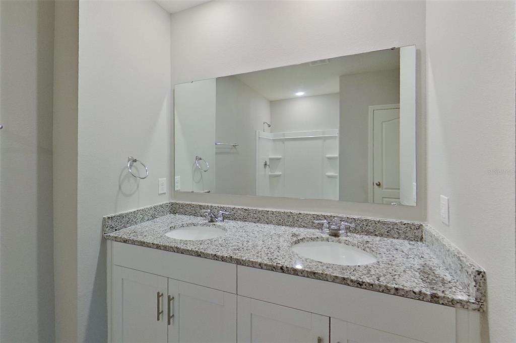 32037 Katelin Circle Leesburg, FL 34748 - Photo 11 of 20 a bathroom with a granite countertop sink and a mirror